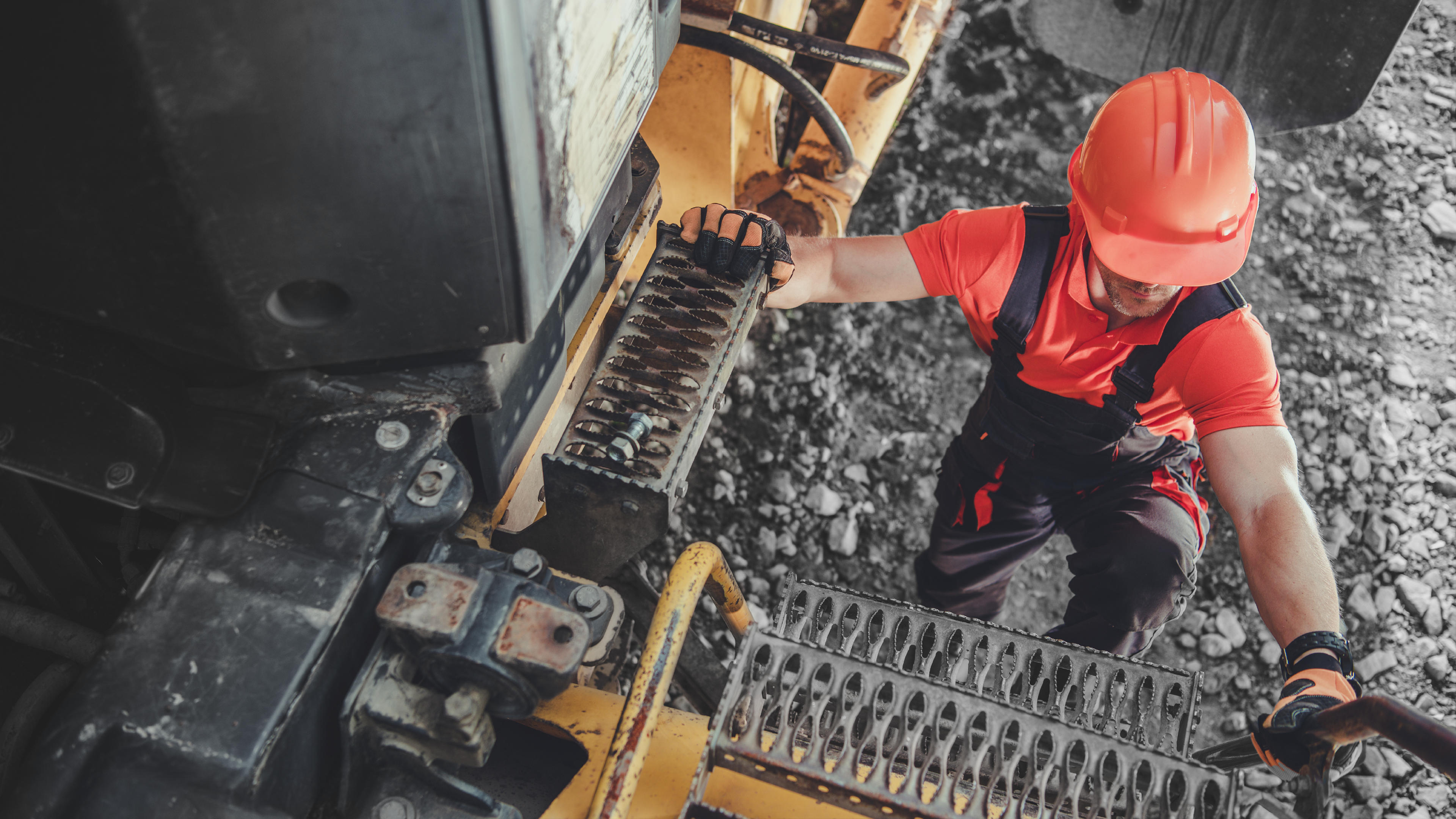 Imagen de hombre trabajador en uniforme subiendo por las escaleras de una máquina industrial