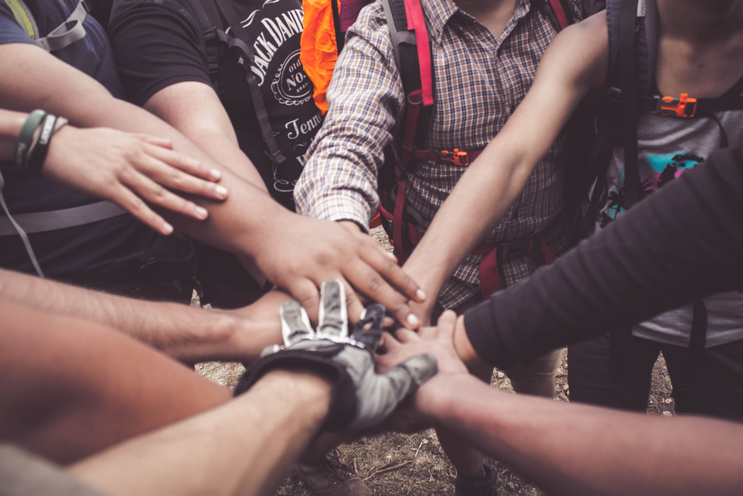 Grupo de personas poniendo sus manos juntas en señal de trabajo en equipo