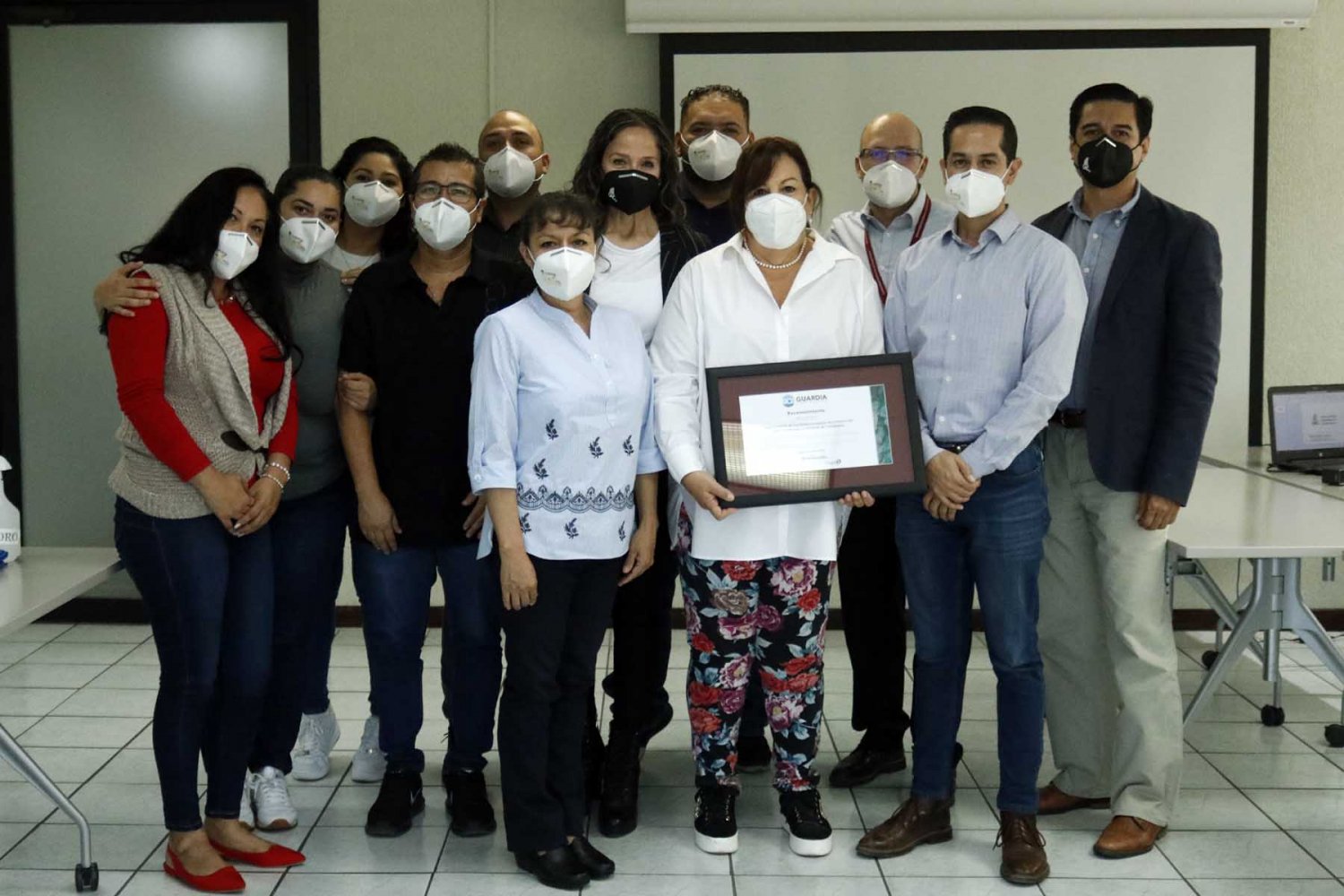 Imagen de un grupo de personas en la Universidad Autónoma de Guadalajara, una de ellas sosteniendo un certificado de reconocimiento por la cadena de suministros ética avalada por Sedex y Guardia Consultores