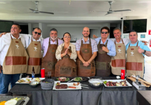 foto grupal mostrando un grupo de profesionales en reunion CANAMI y Guardia Consultores preparando un asado en una dinámica grupal